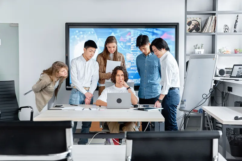 The team shipping together around one laptop